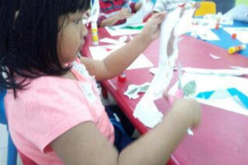 Menggunting kertas didampingi dan diarahkan oleh shadow teacher